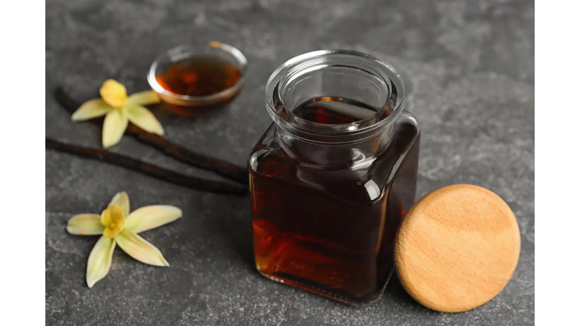 Vanilla extract being poured, showing its light syrupy consistency